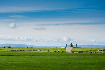 Scenic view of field against cloudy sky