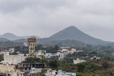 City at the foothill of misty mountain layer at morning from flat angle