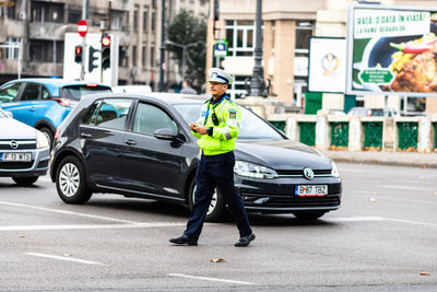 Full length of man standing on road in city