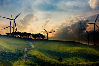 Windmill on field against sky during sunset