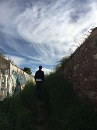 Rear view of man standing against wall