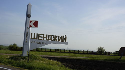 Road sign against sky