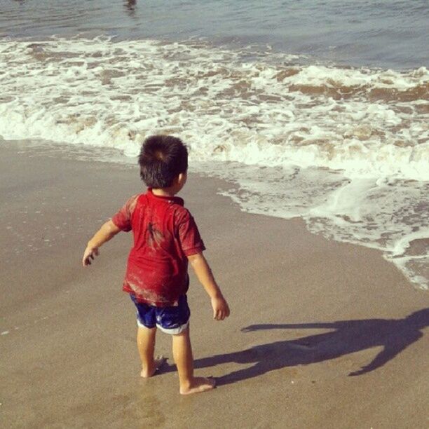 beach, childhood, full length, water, elementary age, shore, sand, sea, lifestyles, girls, leisure activity, casual clothing, boys, innocence, rear view, standing, vacations, person