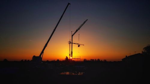 Silhouette cityscape against clear sky during sunset