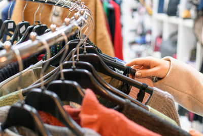 Cropped hand of woman shopping in clothing store