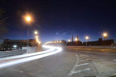 Light trails on road against sky at night