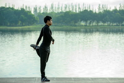 Side view of young man looking at lake