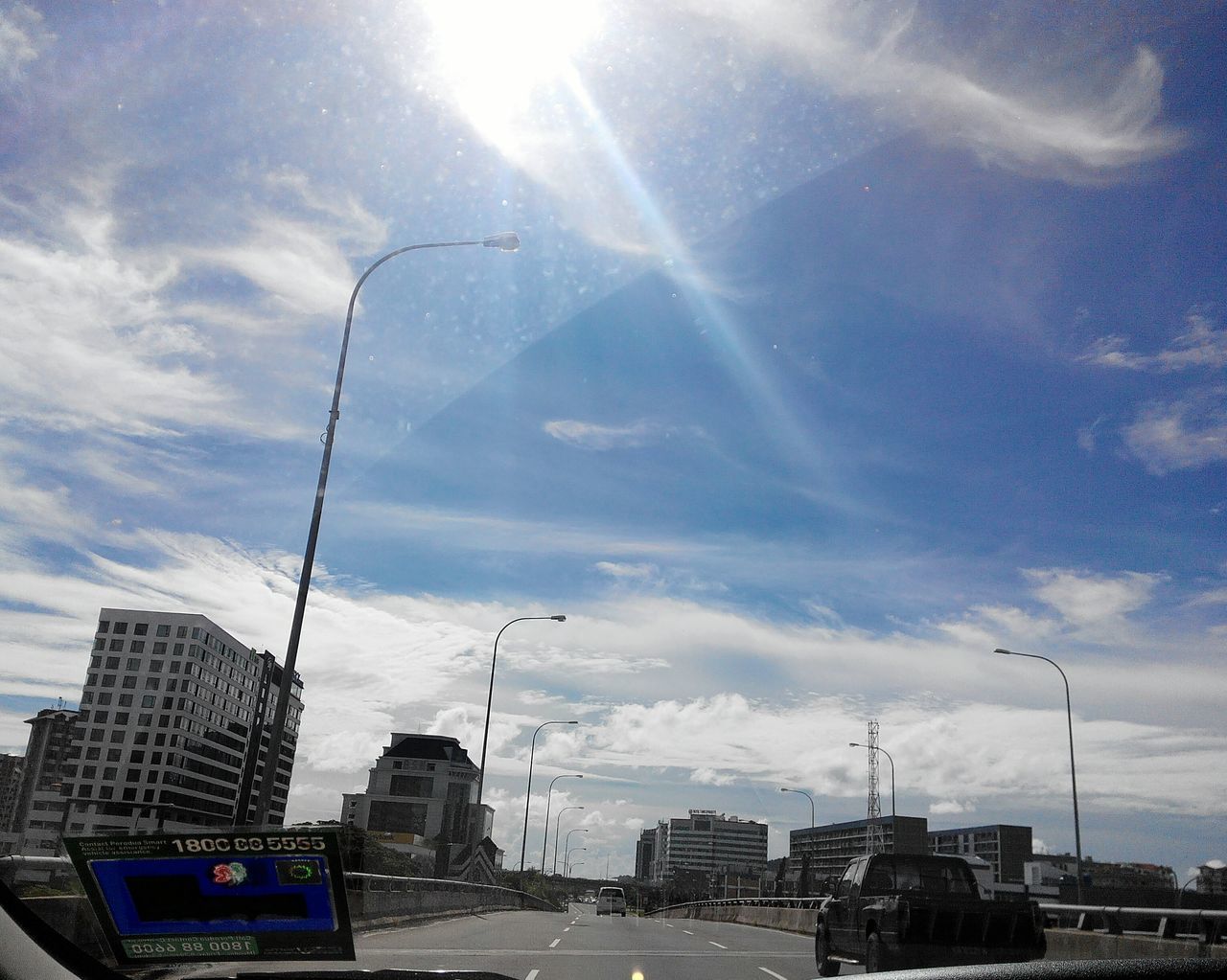 ROAD PASSING THROUGH CITY AGAINST SKY