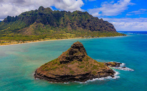 Scenic view of sea and mountains against sky