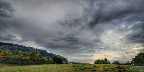 Scenic view of field against cloudy sky