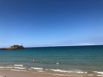 Scenic view of sea against clear blue sky