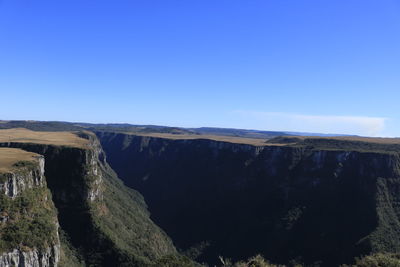 Scenic view of mountains against clear blue sky