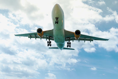 Low angle view of airplane flying against sky