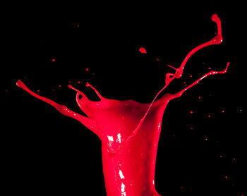 Close-up of drop splashing against black background