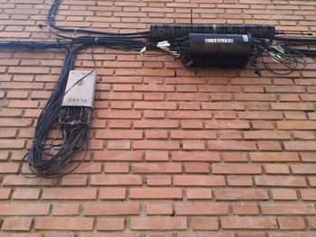 Low angle view of electric lamp on brick wall