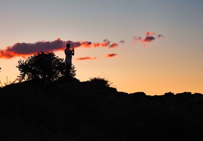 Silhouette man standing against sky during sunset