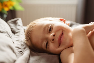 Portrait of baby lying on bed at home