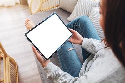 Midsection of woman using digital tablet