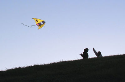 Low angle view of kite flying over landscape