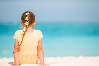 Midsection of woman on beach against sky