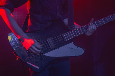 Midsection of musician playing guitar