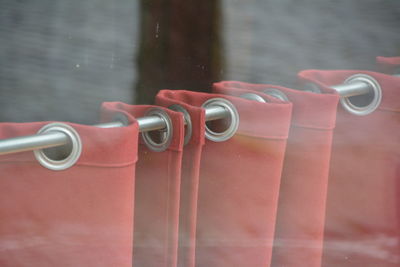 Close-up of red curtain against glass window