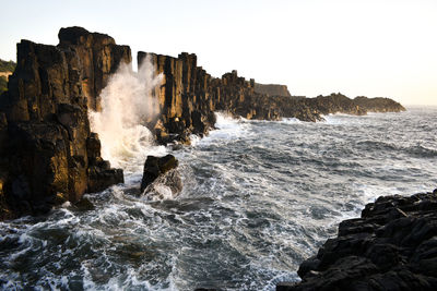 Scenic view of rocks in sea against sky