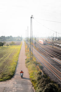 High angle view of a road next railway tracks passing through field