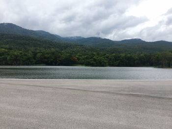 Scenic view of lake by mountains against sky