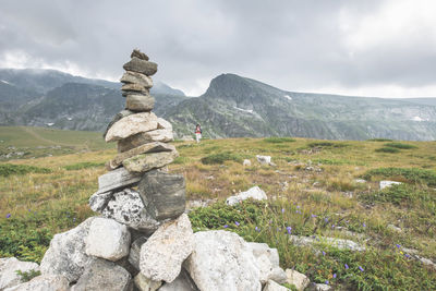 Stack of rocks with woman walking in background