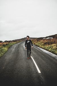 Full length of man standing on road against sky