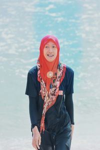 Woman in hijab walking against sea