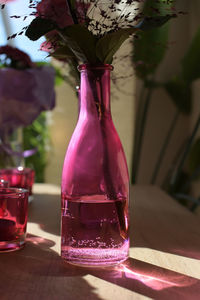 Close-up of pink rose in glass vase on table