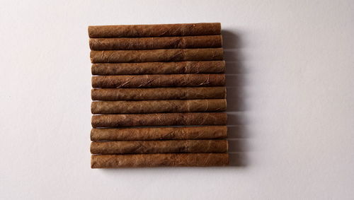 Directly above shot of cigars on white background