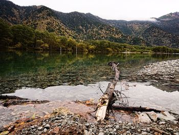 Scenic view of lake by mountains against sky