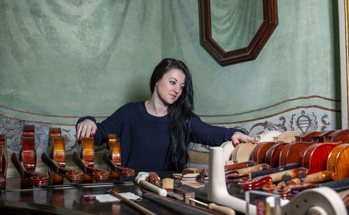 Fascinating violinist showing his collection of handcrafted violins at home