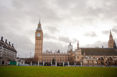 Buildings in city against cloudy sky