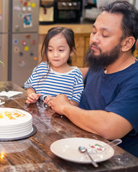 Portrait of father with son on table