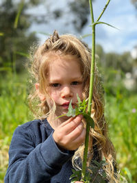 Portrait of young woman against plants