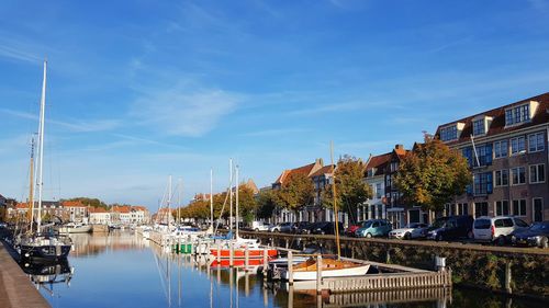 Boats moored at harbor against buildings in city