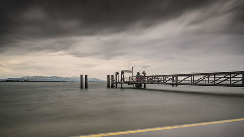 Pier over sea against sky during sunset