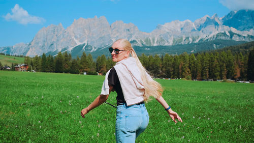 Portrait of woman standing on field against mountain