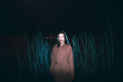 Rear view of woman standing against black background