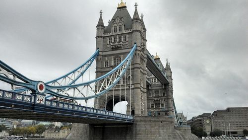 Low angle view of bridge against cloudy sky