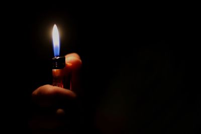 Close-up of lit candle in dark room