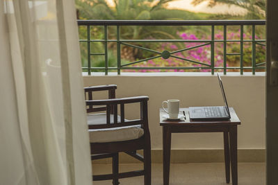 Freelancer or businessman working remotely with laptop on hotel balcony at resort while traveling. 