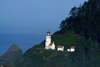 Lighthouse by sea against sky