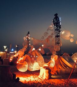 Low angle view of illuminated lanterns against sky at night