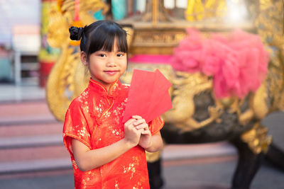 Portrait of cute girl with red flowers in background
