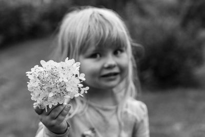 Close-up portrait of cute girl holding flowers